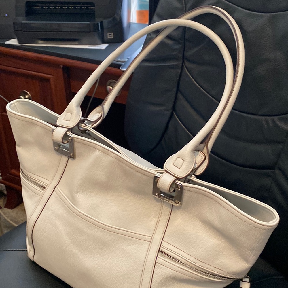 White satchel. Brand name: Tignanello. Size: 11”x 19”. Four outside pockets.